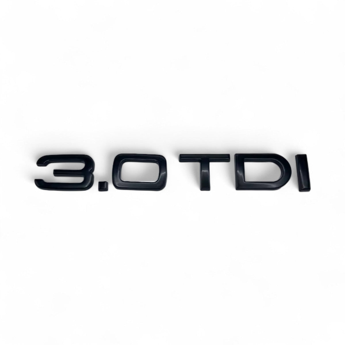 Badge de coffre 3.0 TDI noir monté sur le hayon d'une Audi