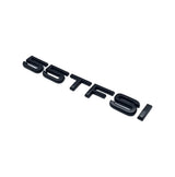 Badge de coffre 55 TFSI noir monté sur le hayon d'une Audi