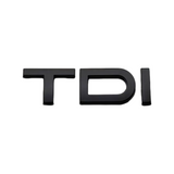 Pose du badge de coffre TDI noir sur le hayon d'une Audi