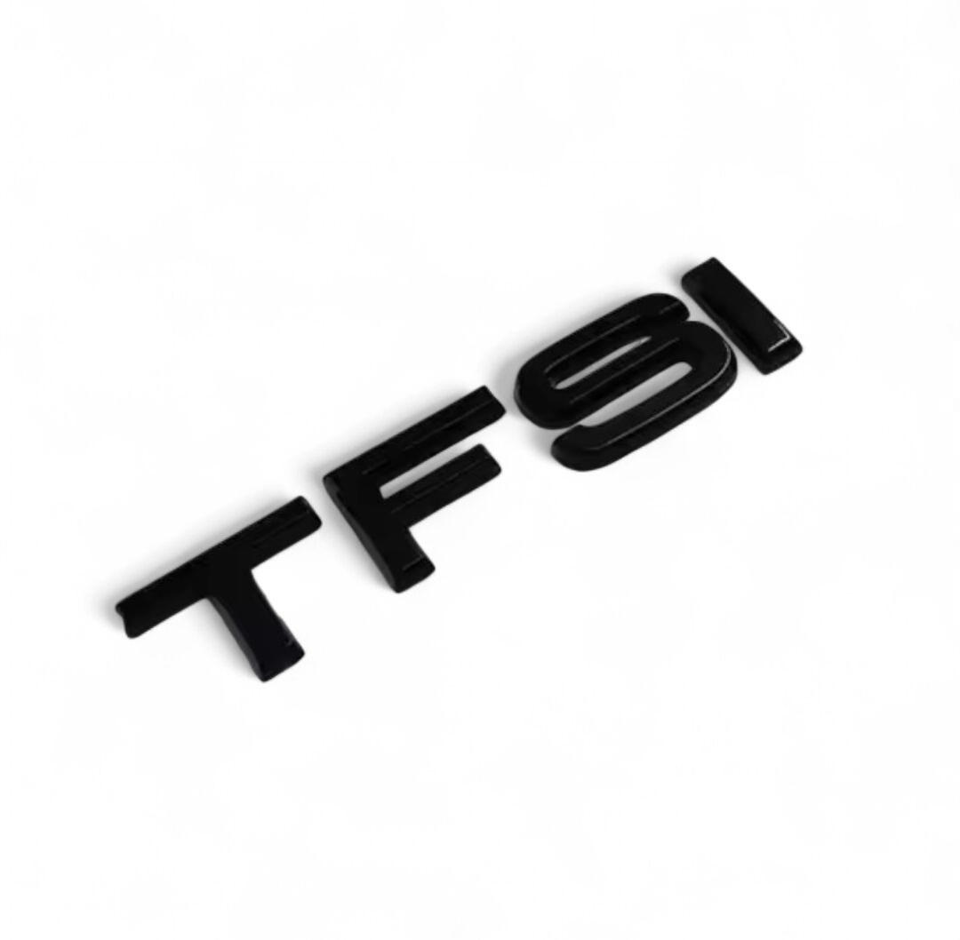 Pose du badge de coffre TFSI noir sur le hayon d'une Audi